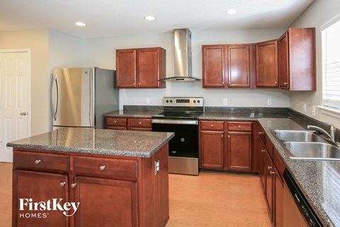 a kitchen with wood cabinets and granite counter tops and stainless steel appliances
