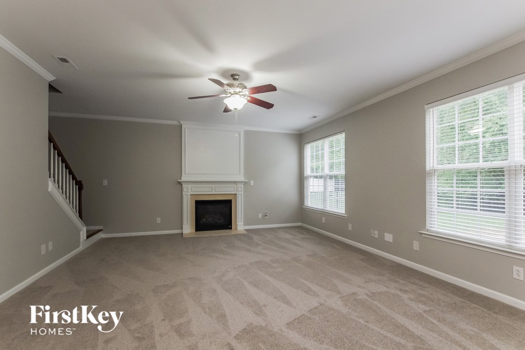 a living room with a fireplace and a ceiling fan