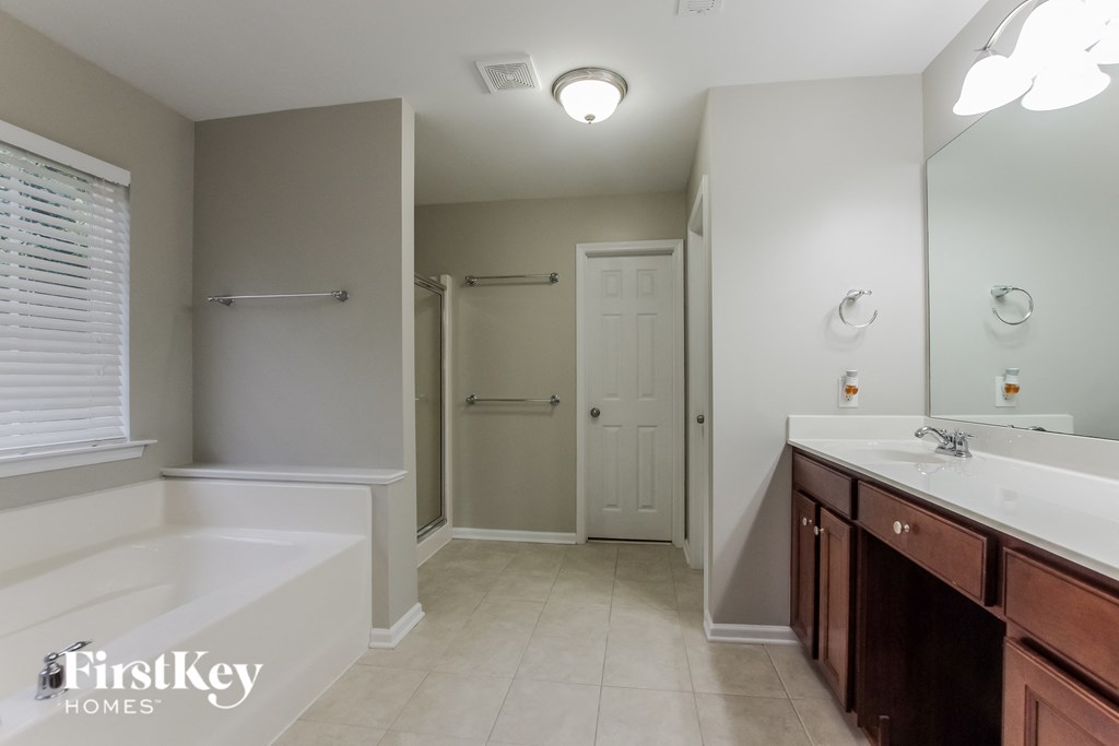 a bathroom with a large tub and a sink and a mirror