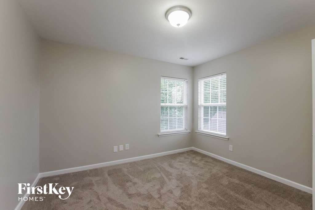 a bedroom with a carpeted floor and two windows