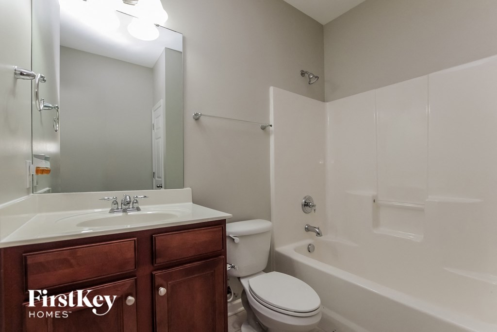 a bathroom with a toilet sink and tub and a mirror