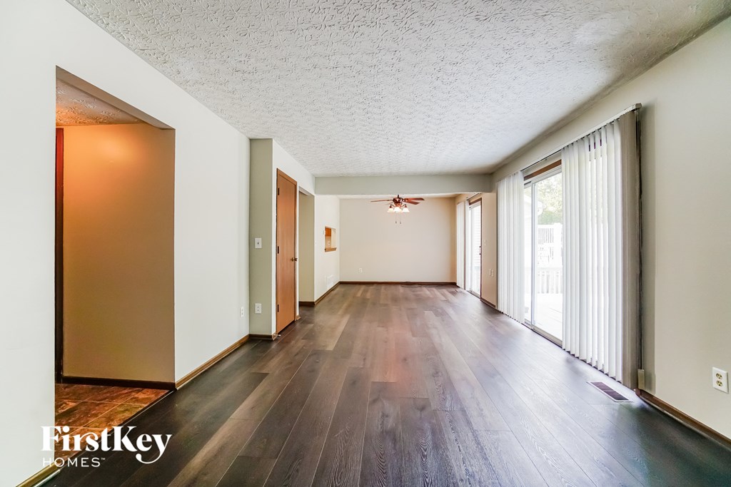 the living room and dining room of an empty house with wood floors and a large