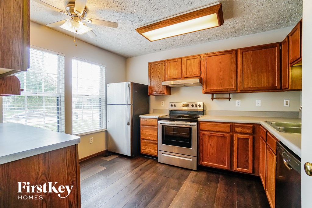 a kitchen with wooden cabinets and stainless steel appliances