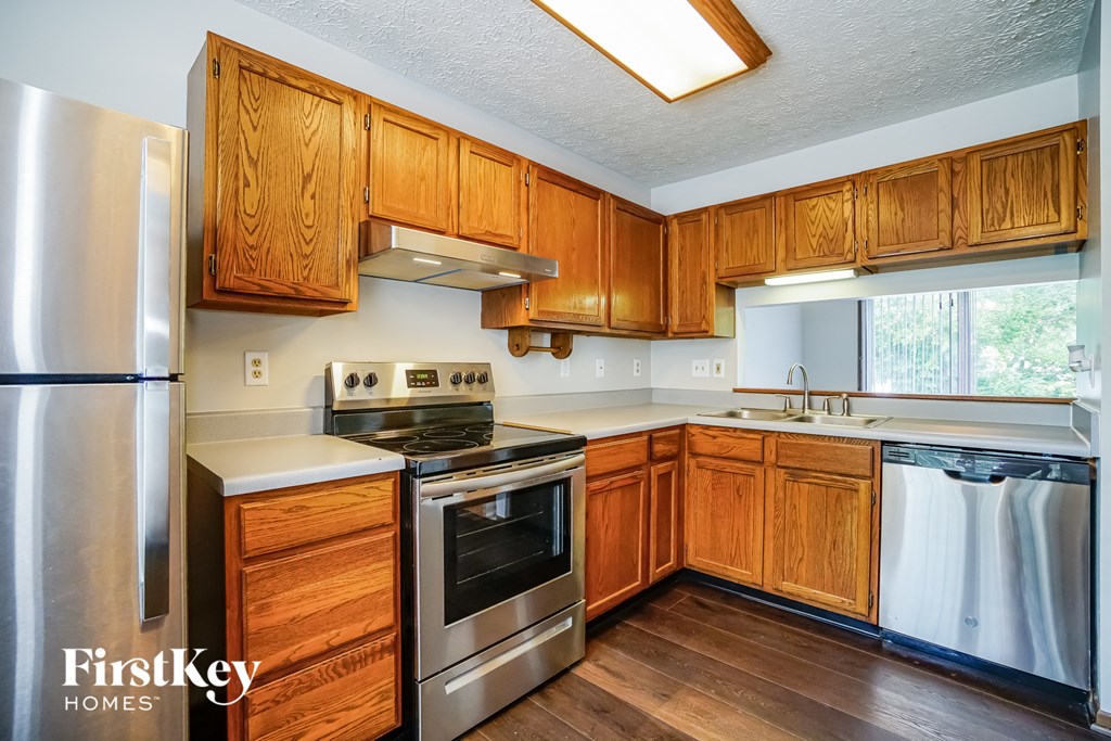 a kitchen with wooden cabinets and stainless steel appliances