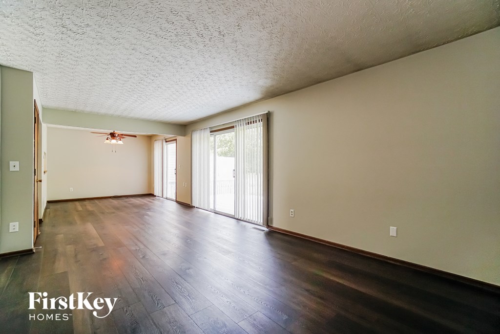 the living room and dining room of an empty house with wood floors and a sliding