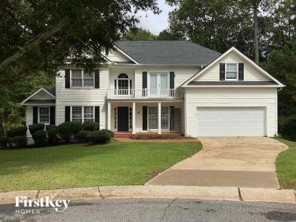 A white house with a black roof and a garage door.