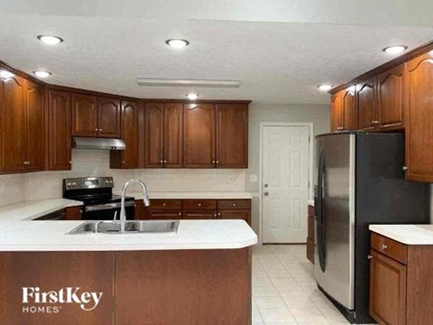 A kitchen with wooden cabinets and a stainless steel refrigerator.