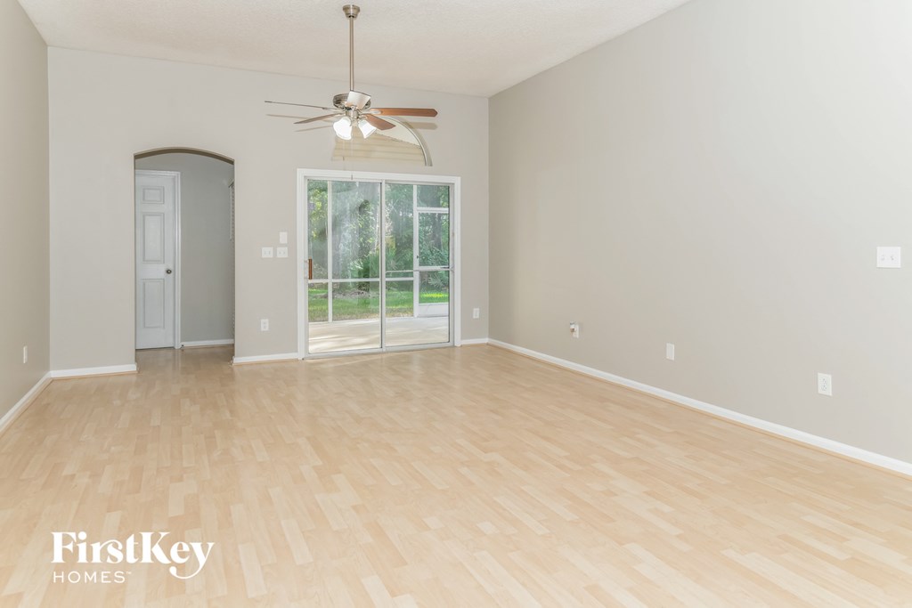 A room with a fan and a sliding glass door.