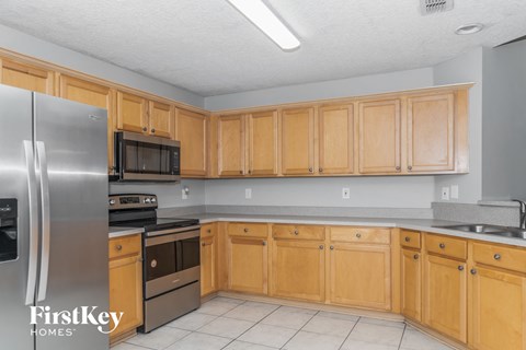 A kitchen with wooden cabinets and a stainless steel refrigerator.