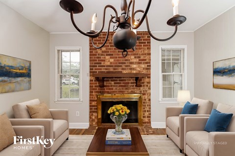 A living room with a fireplace and a chandelier.