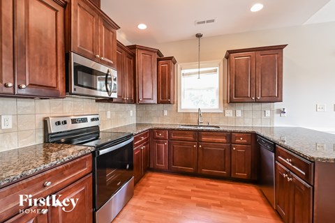 a kitchen with wood cabinets and granite counter tops and black appliances