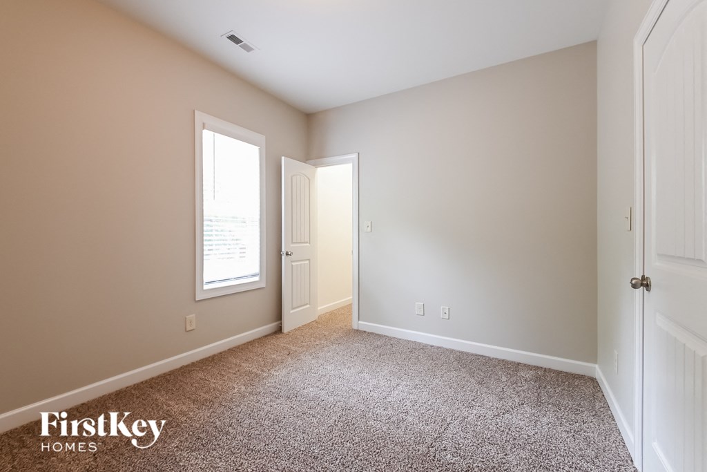 a bedroom with a carpeted floor and a door to a closet