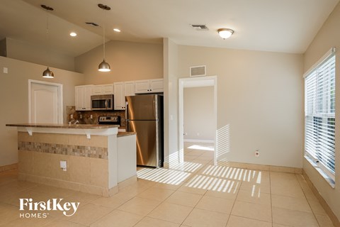 A kitchen with a refrigerator, microwave, and oven is shown.