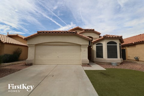 A house with a garage and a driveway in front of it.