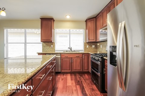 A kitchen with wooden cabinets and a stainless steel refrigerator.