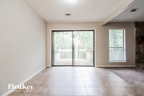 an empty living room with sliding glass doors to a balcony
