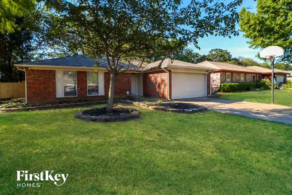 a small brick house with a tree in the front