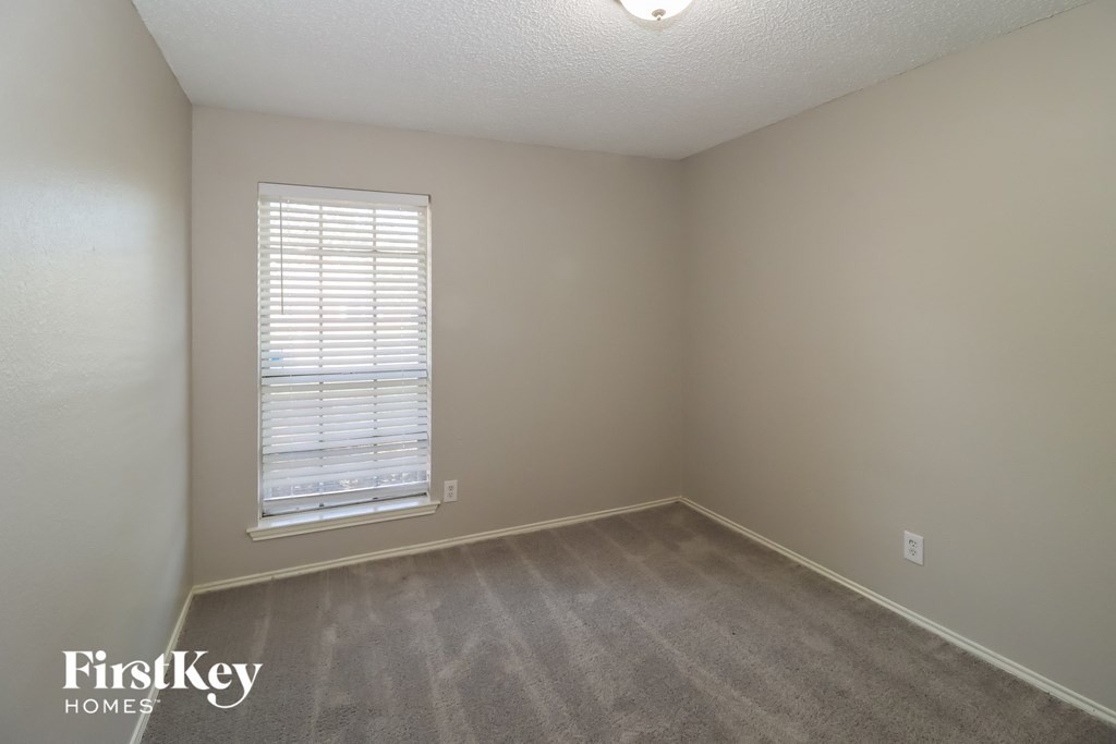 a bedroom with a carpeted floor and a window