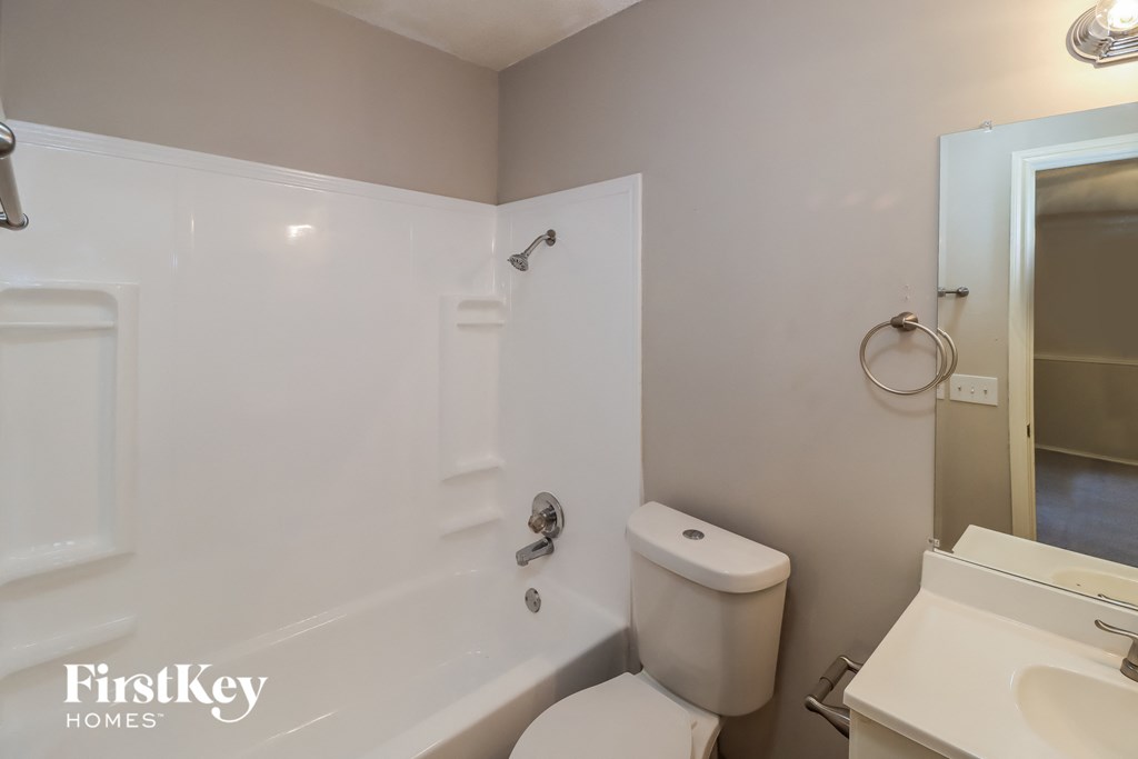 a bathroom with a toilet and a tub and a sink