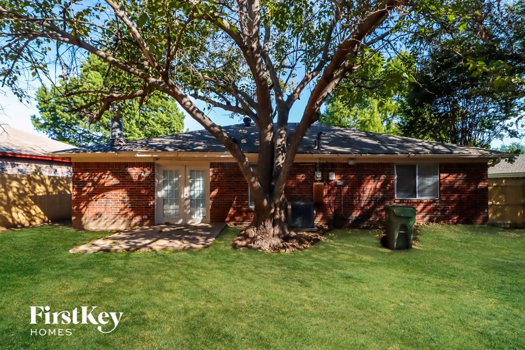 a small brick house with a tree in the yard