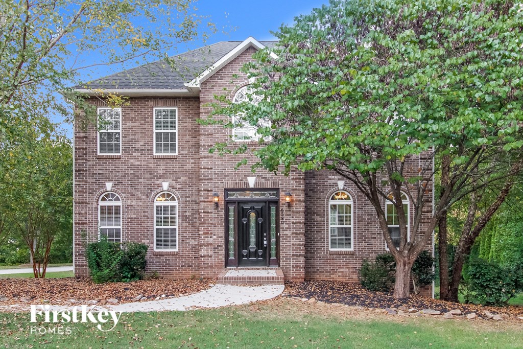 A brick house with a black front door and windows.