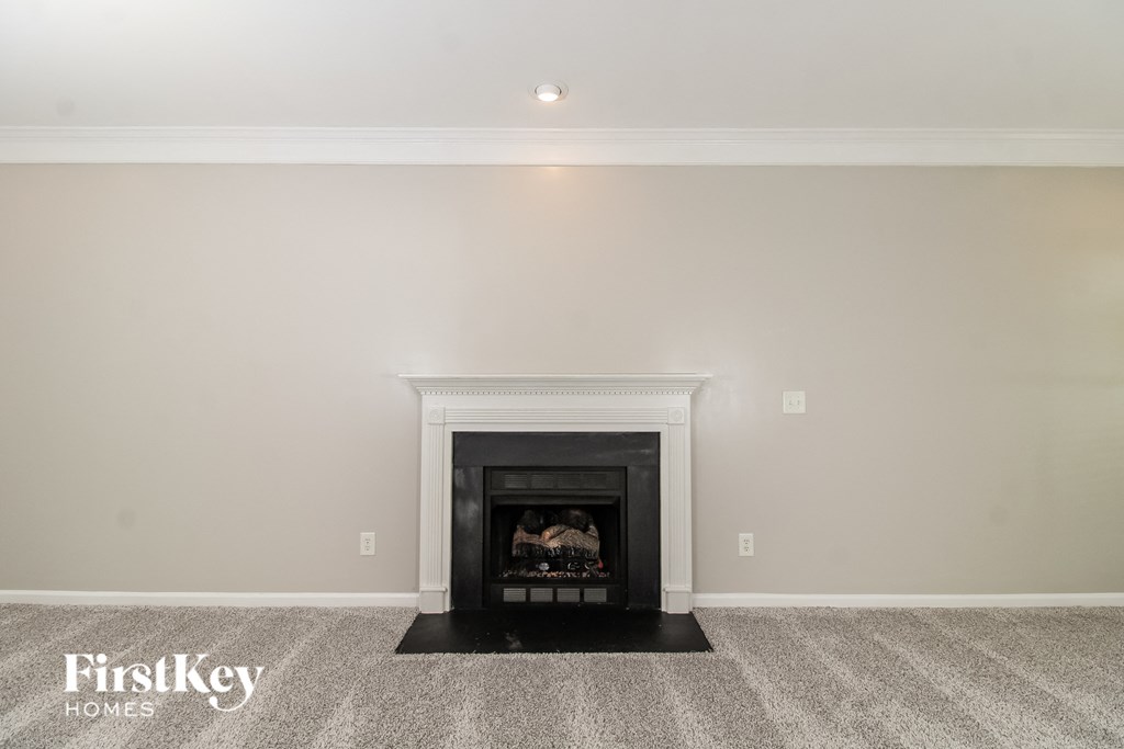 A fireplace in a room with a carpeted floor.