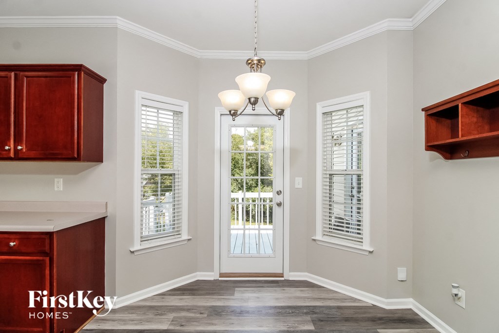A well-lit foyer with a chandelier and a door leading to a deck.