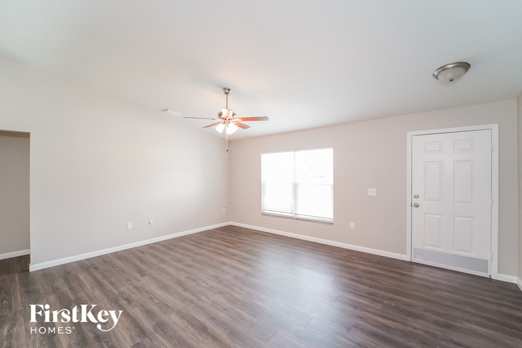 A room with a ceiling fan and a door.