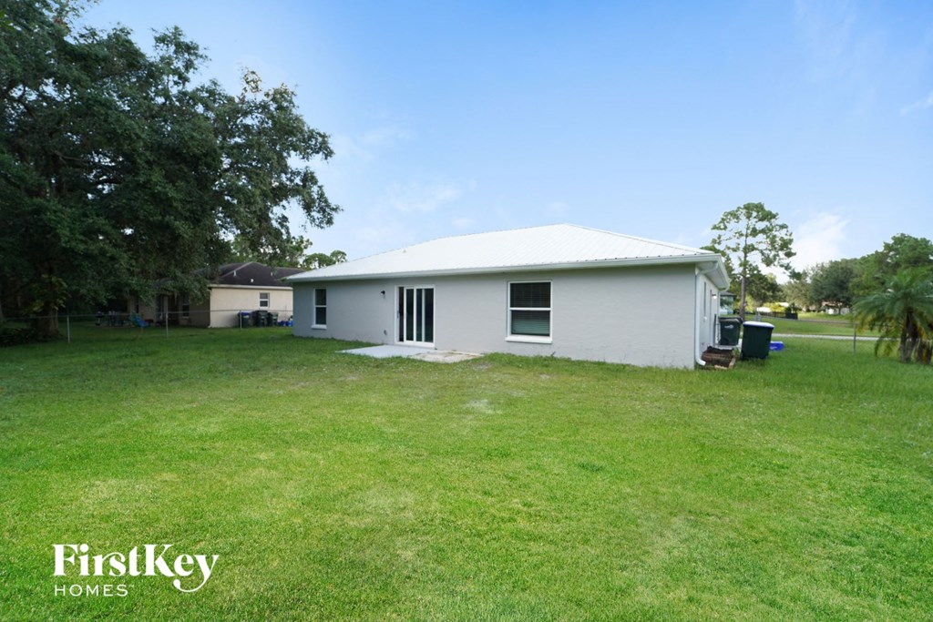 A white house with a green lawn in front of it.