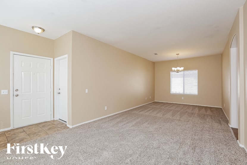 A room with a carpeted floor and a door leading to another room.