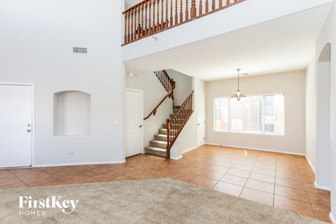A spacious living room with a staircase leading to the upper floor.