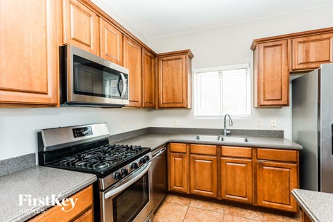 A kitchen with wooden cabinets and a stainless steel refrigerator.
