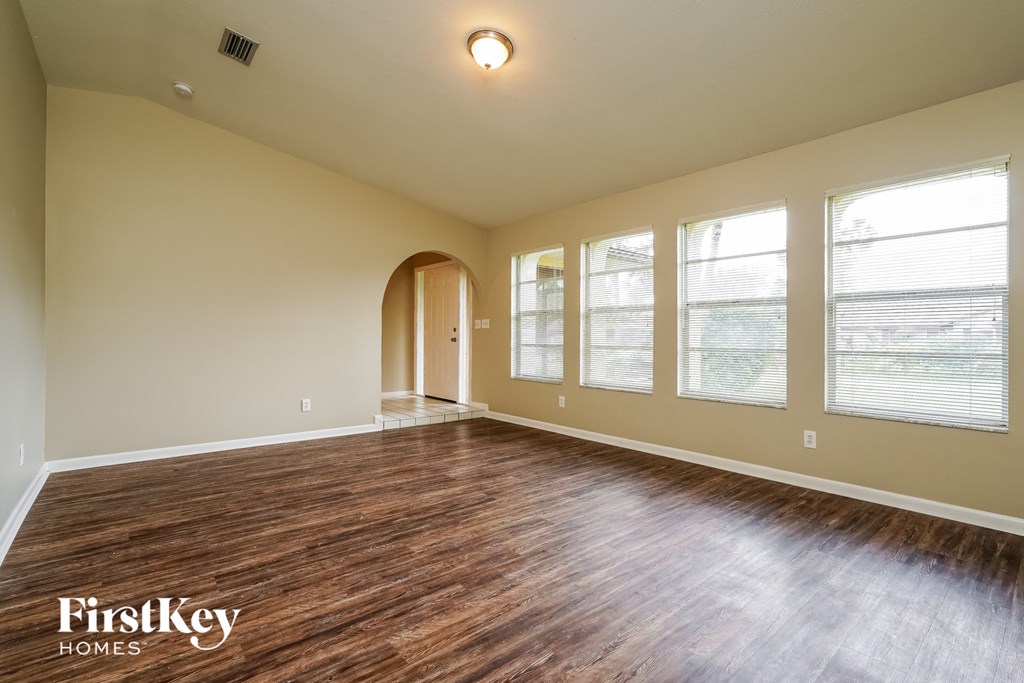 Empty room with wooden floors and a light on the ceiling.