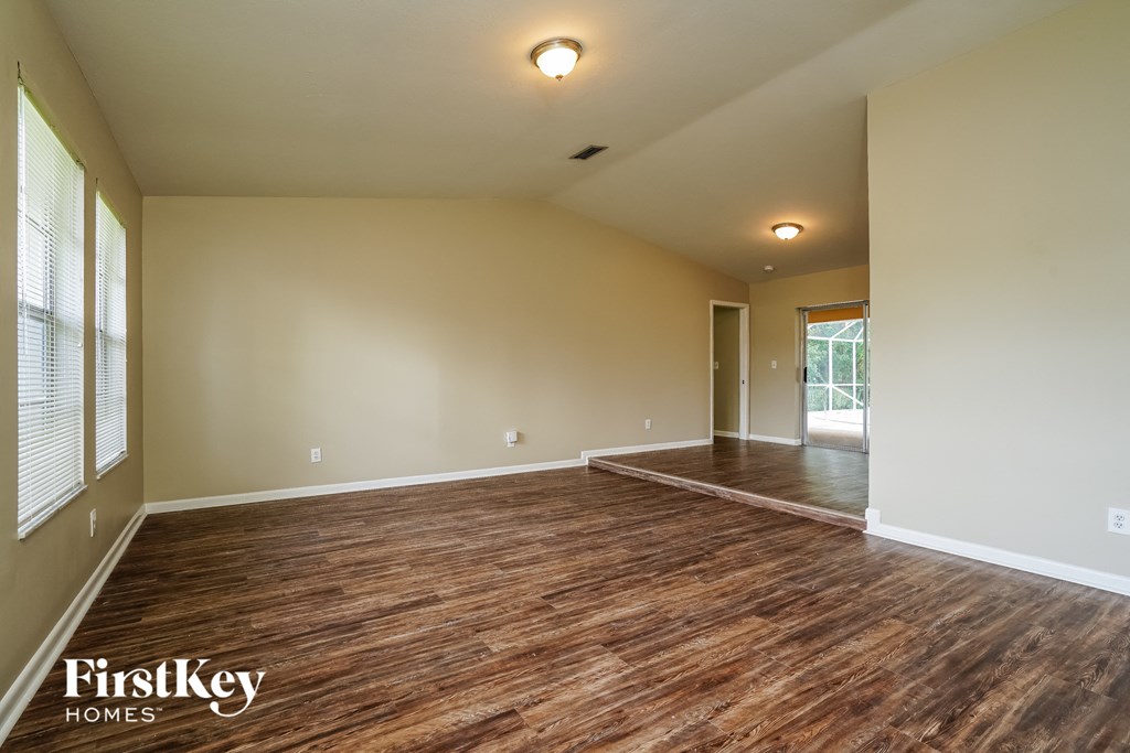 A room with wooden flooring and a FirstKey Homes logo.