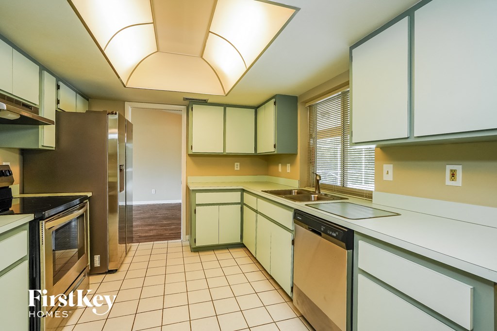 A kitchen with a refrigerator, microwave, and dishwasher.