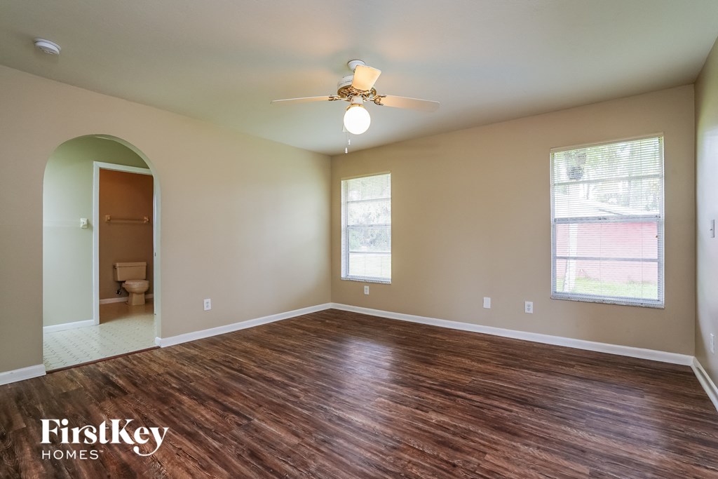 A room with wooden floors and a ceiling fan.