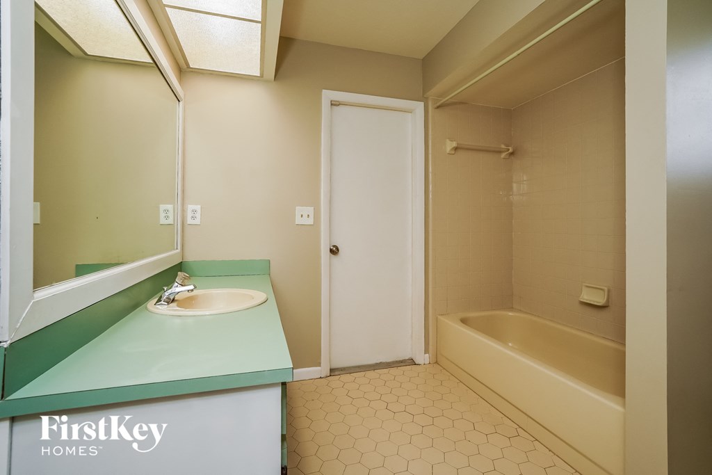 A small bathroom with a sink, toilet and bathtub.
