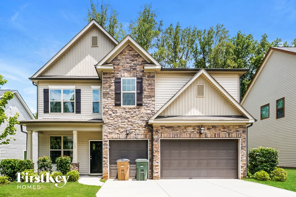 A modern two-story house with a stone pillar in the front.