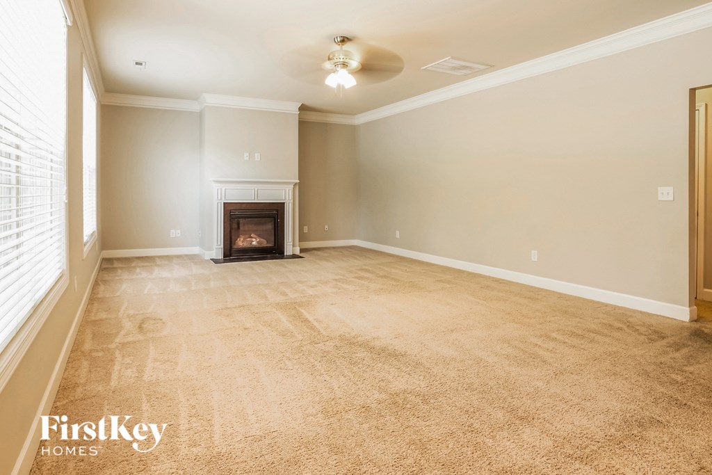 A living room with a fireplace and a carpet.