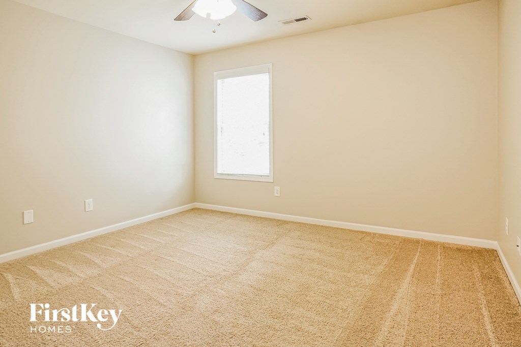 A room with a carpeted floor and a window.