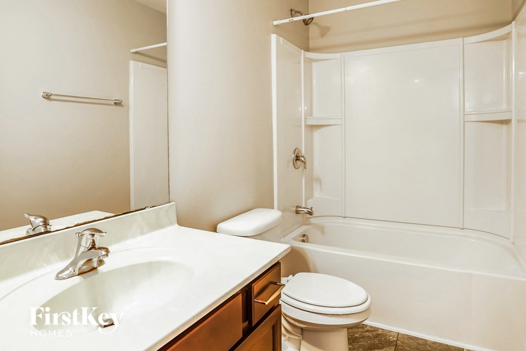 A white bathroom with a sink, toilet and bathtub.