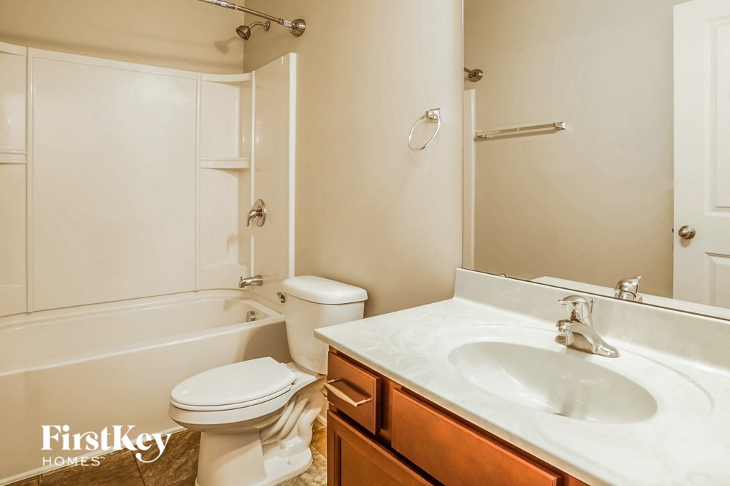 A white bathroom with a toilet, sink, and bathtub.