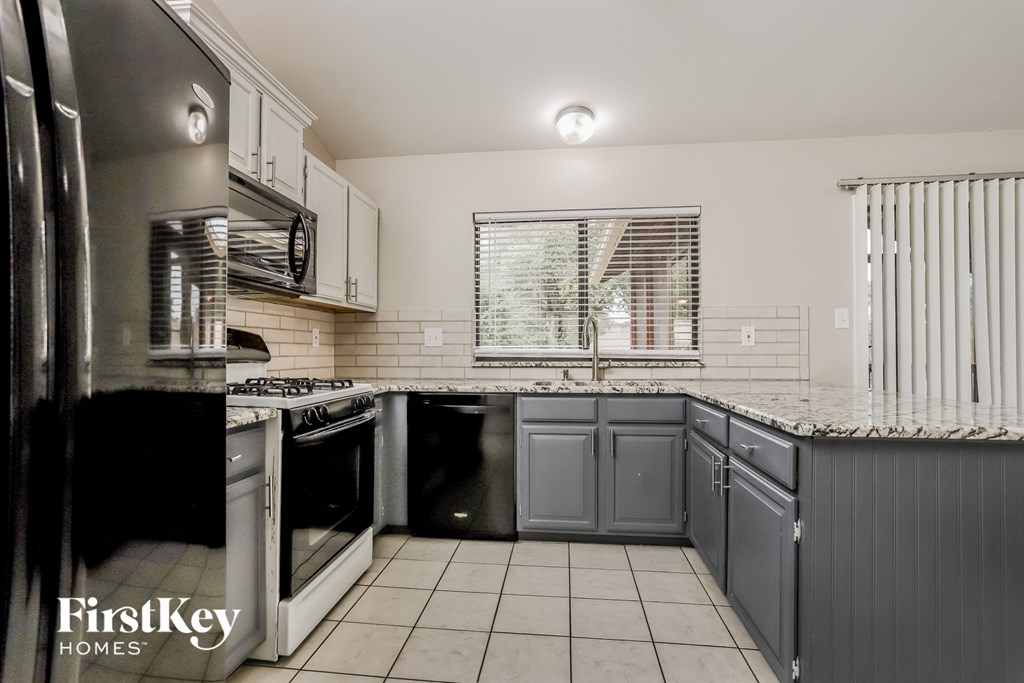 A kitchen with a stove top oven and a refrigerator.
