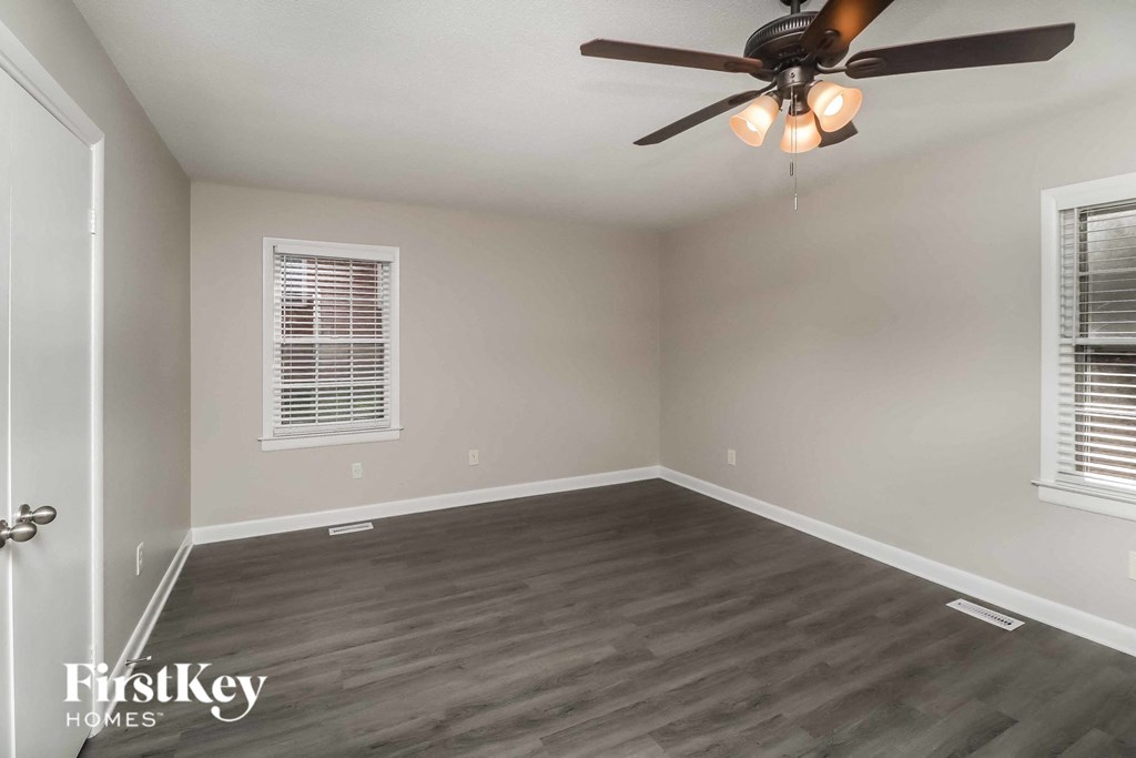 a living room with wood floors and a ceiling fan
