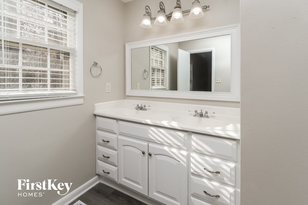 a white bathroom with two sinks and a mirror