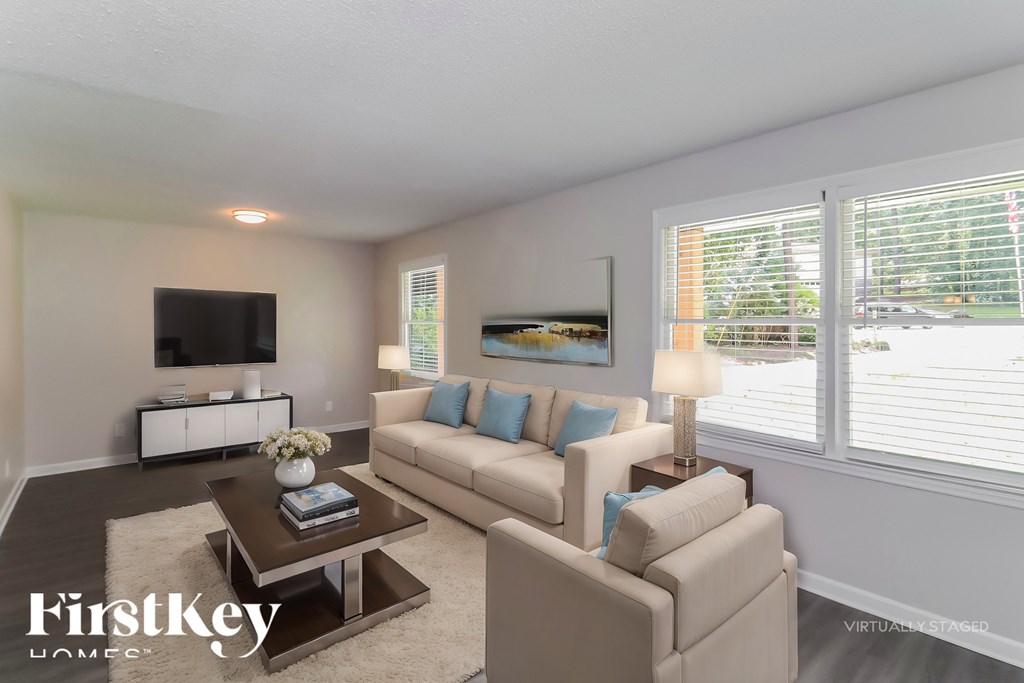 A living room with a white couch and a coffee table.