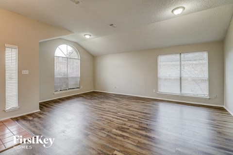 the living room with wood floors and a large window
