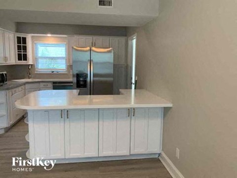 a kitchen with a white counter top and a refrigerator