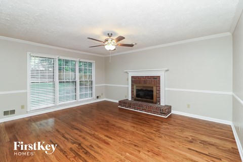 a living room with a fireplace and a ceiling fan