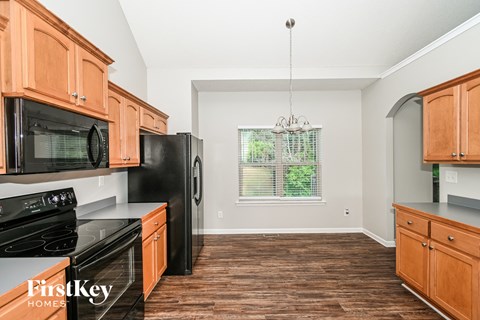 A kitchen with wooden cabinets and black appliances.